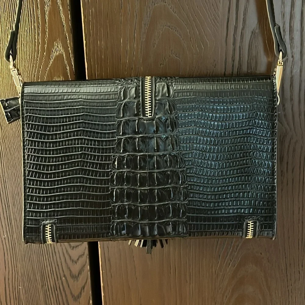 No brand black faux leather purse with black tassel and zippers for design.